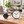 Black bicycle-shaped metal table clock with a white dial – bicycle table clock on a desk beside a laptop